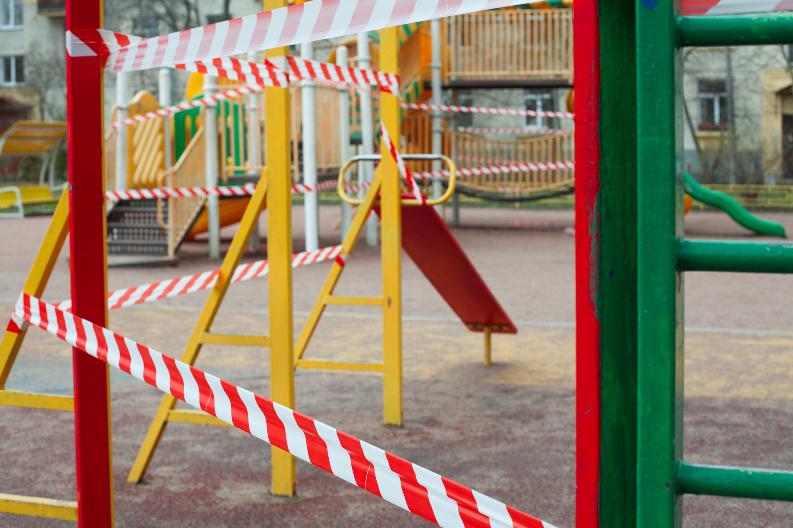 Closed playground is blocked by red warning tape. Quarantine Covid-19.